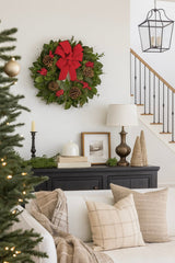Christmas wreath with red bow berries and pinecones on wall in a living room with christmas decor