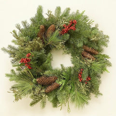 Christmas wreath with greenery, pinecones, and red berries on a white background