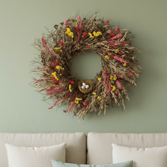 bright botanical spring wreath with pink, red and yellow florals above a cream couch