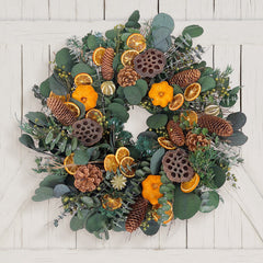 H Potter preserved decorative wreath with greenery, pine cones, and oranges on a white wooden background