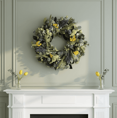bright spring wreath with decorative blue and yellow flowers above a white mantel