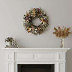 Decorative spring botanical wreath on a white wall above a fireplace