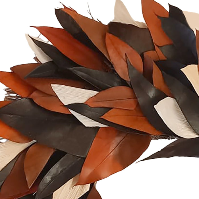 A close-up of layered feathers in warm brown, black, and off-white tones against a plain white background.