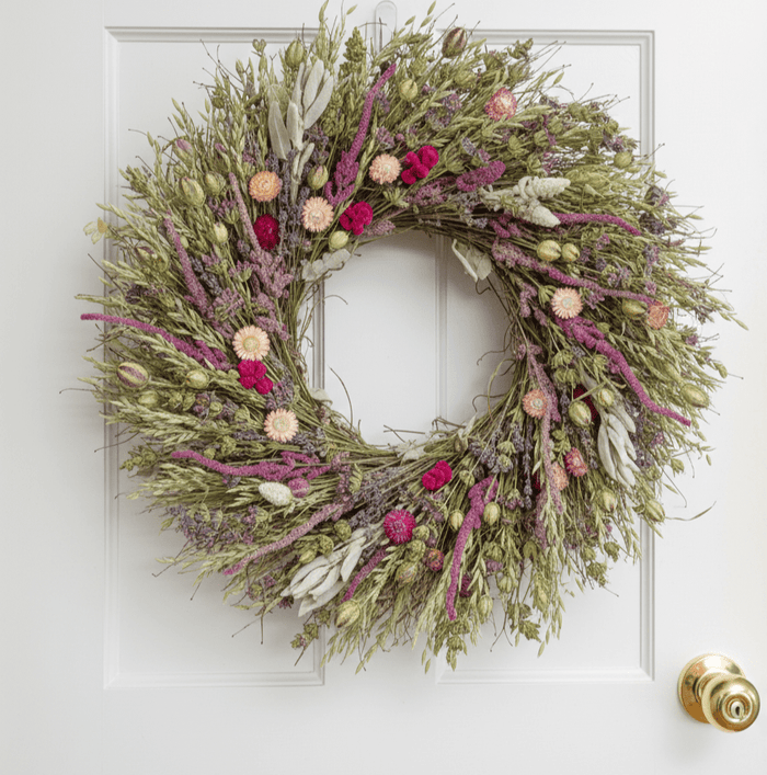 floral spring wreath with colorful botanicals on a white door