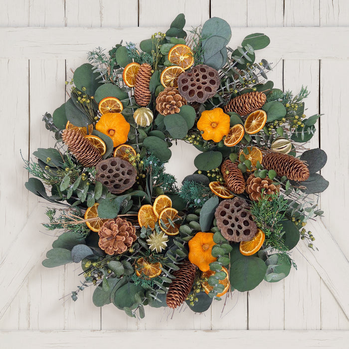 H Potter preserved decorative wreath with greenery, pine cones, and oranges on a white wooden background