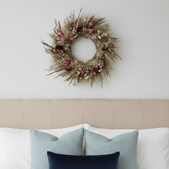 decorative spring wreath with bright seasonal botanicals above a bed